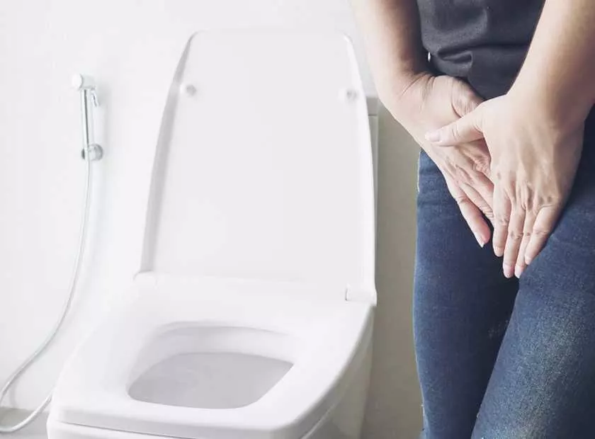 Woman holding hand near toilet bowl - health problem concept